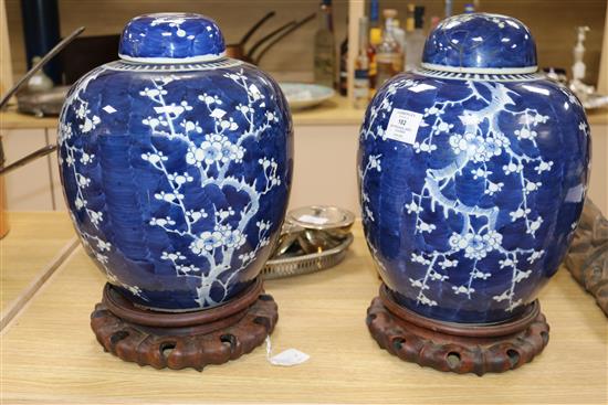 A pair of Chinese prunus pattern vases and covers with hardwood stands H.41cm